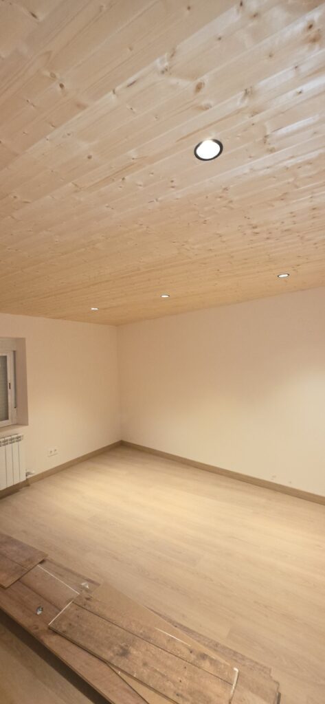 Dormitorio rehabilitado con techo de madera en León