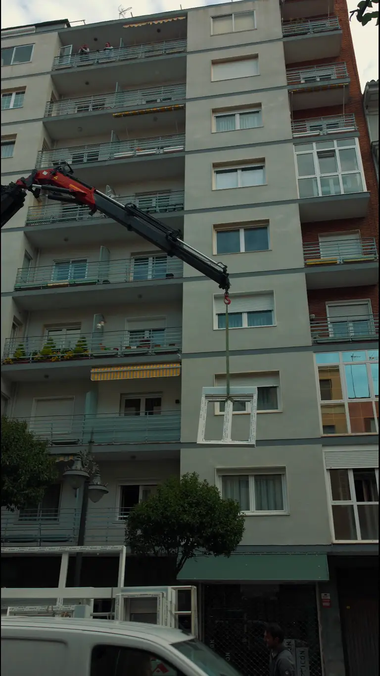 Obra en fachada de edificio en León con grúa